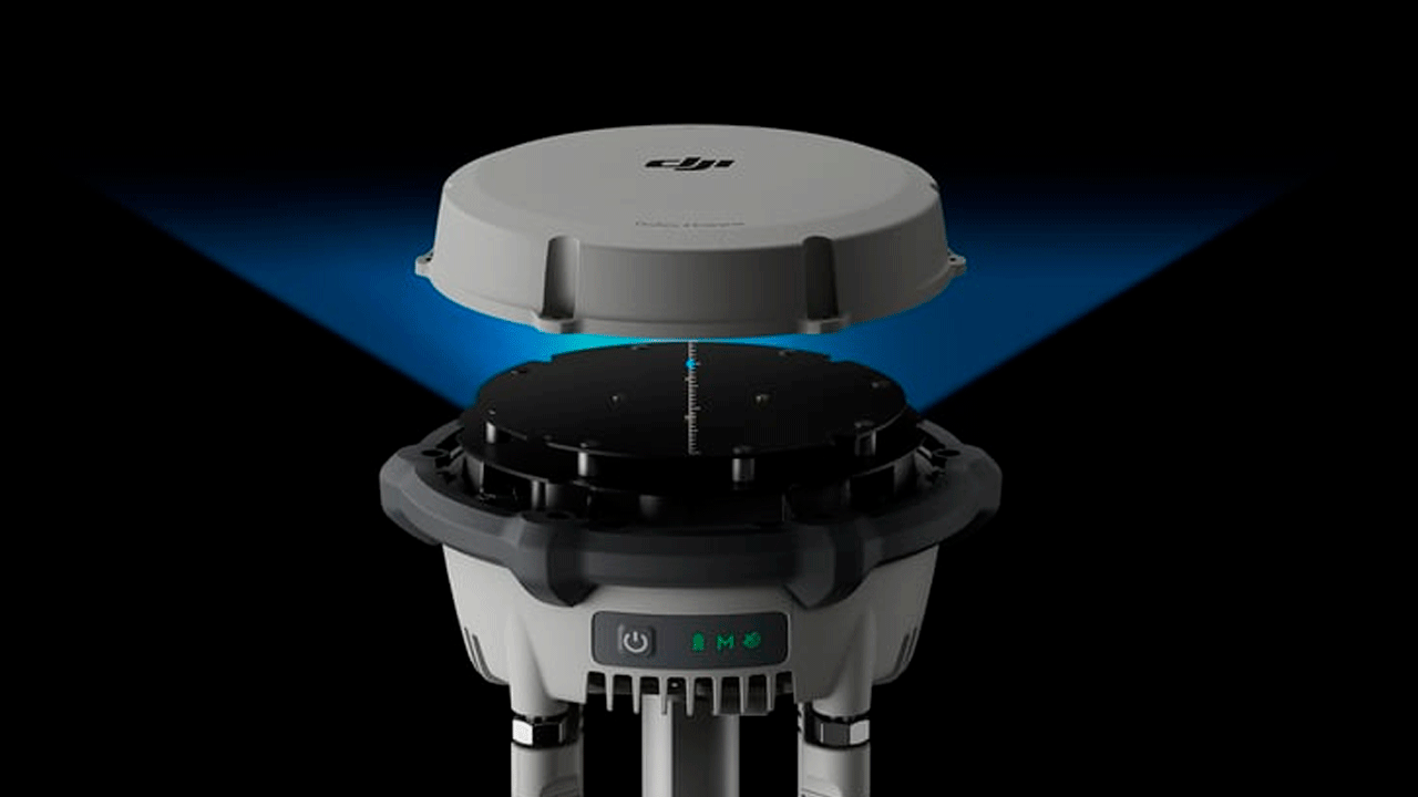 DJI D-RTK 3-станция с отделенной верхней крышкой, демонстрирующая внутренние компоненты и электронику. Устройство белого цвета с черными внутренними элементами и голубой подсветкой, используемое для высокоточного позиционирования дронов