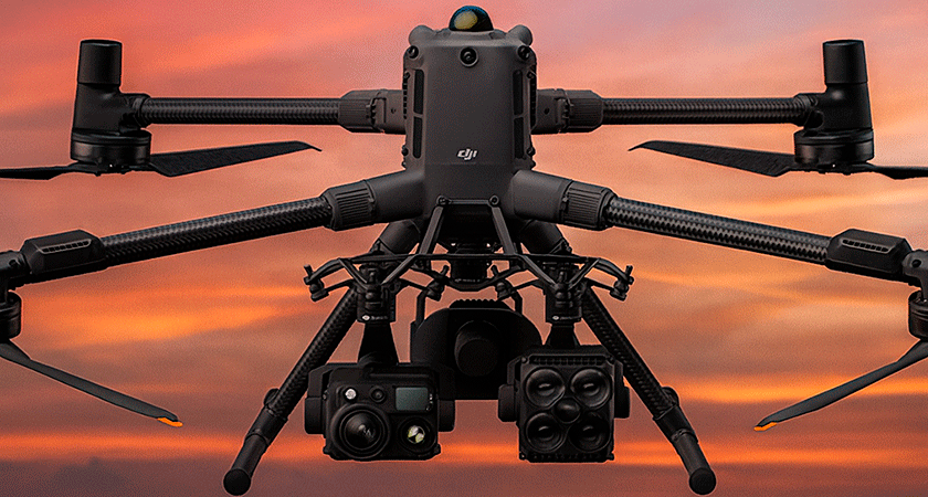 Квадрокоптер DJI Matrice 400 с установленными модулями и камерами, летит на фоне заката и горного пейзажа